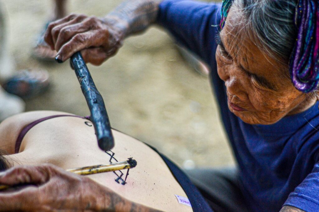 Whag-od doing traditional tattoo | Featured image of the Kalinga Tattoo meaning blog